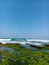 View of the beach from the edge of the ocean with the sky