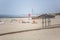 View of a beach with four straw parasol, summer weather with tourist people taking sunbathing