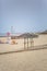 View of a beach with four straw parasol, summer weather with tourist people taking sunbathing