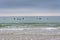 View from the beach of a group of surfers waiting for the waves, a cloudy afternoon