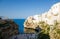View of the beach lama monachile cala porto and white buildings on grottos and cliffs in the town of Polignano a mare