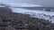 View of the beach of round stones, February day. Coast of the Barents sea