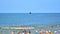 View of the beach. Tourists, sunbeds and windbreaks on summer hot day. Tourists on the beach on summer they sunbathe, rest and swi