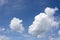 View on beautiful cumulus clouds, looking like floating pieces of cotton, in a perfect blue sky.