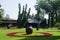 view of a beautiful decorated garden in front of bran castle in romania with wooden shed, giant vase and artificial pond