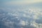 View of beautiful dreamy fluffy abstract white cloud with blue sky and sunrise light background from airplane window
