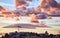 View of beautiful fluffy pastel orange clouds over city buildings