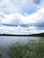 View at Beautiful Lake Panorama with Reeds and Clouds
