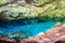 View of beautiful natural pool of crystal clear water formed in a rocky cave with stalagmites and stalagmites