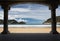 View on beautiful sandy beach la concha of san sebastian through under arch arcade, basque country, spain