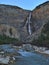 View of beautiful waterfall Takakkaw Falls in the evening with wild river in front in Yoho National Park, Canada in the Rockies.