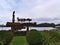 View of beautiful wooden welcome sign in Carrot Park, Port Hardy, Vancouver Island surrounded by bushes on cloudy day.