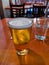 View of a beer on the table of a restaurant, next to a glass of water