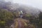 View from behind - lone hiker in bright green jacket during trek to Pic Boby aka Imarivolanitra in Andringitra National Park, on