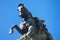 View from below of a bronze statue of a horse.