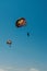 View from below parasailing fly high in sky with colorful parachute at beach