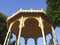 View from below of top of traditional Canarian Music kiosk under blue sky. Gazebo or semicircular structure for outdoor concerts.