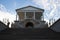 View from below of a wide staircase and a staircase with openwork railings leading to the gallery of