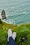 The view is best from above. High angle shot of an unrecognizable woman sitting on cliff and admiring the view.