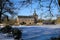 View beyond bare trees over frozen lake on medieval castle in winter against blue sky - Wegberg, tuschenbroich, Germany