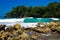 View beyond sharp rocks on turquoise rough sea with wave breakers and strong surf - Blue lagoon, Portland, Jamaica