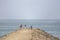 View of a big seawall on atlantic ocean and people enjoying the view and fishing