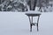 View of a bird bath covered in snow during a winter blizzard