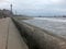 view of blackpool promenade in winter with stormy sea tower and central pier with unidentifiable people walking along the