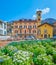 The view through the blooming flower bed on scenic facade of historical house on Piazza Indipendenza of Bellinzona, Switzerland