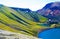 View on  blue crater lake with volcanic lava ash after eruption with green valley