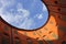 View of blue sky and clouds through oval rooftop of public theater building in Ferrara, Italy for commercial real estate concept