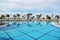 View of blue swimming pool, sunbeds and palm trees near the beac