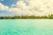 View of blue turquoise lagoon and far line of palm trees on tran