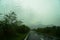 View of blurred road way and mountain view with raindrop on car