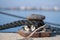 View on bollard in the port with mooring lines on blue sea background