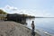 View of Bolsena Lake. A child is playing in foreground. A typical restaurant on wooden pilework in the background. Bolsena, Lazio