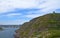 View from he bottom of Signal Hill covered with lush green grass towards St John`s harbour