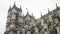 View from the bottom on the Westminster Abbey exterior details against the grey cloudy sky. Action. It is a large