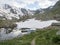 View from Bremer Hutte at hiking trail with lake from melting snow tongues and snow-capped moutain peaks, lush green