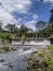 view of the bridge from below and the river with its waterfalls. boulders that adorn the banks of the river