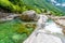 View from Bridge Ponte dei Salti to Verzasca River at Lavertezzo - clear and turquoise water stream and rocks in Ticino - Valle