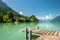 View of Brienz lake with clear turquoise water. Wooden pier. Traditional wooden houses on the shore of Brienz lake in