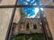 View of the bright summer blue sky through the ruined windows of the old stone church. Arch windows, stone walls. Empty abandoned