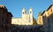 View of the brightly sunlit church Trinita dei Monti against clear blue sky atop the Spanish Steps
