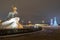 View of the bronze horseman in the evening with a Christmas tree.