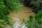 A view of the brown muddy river water flowing into the gorge