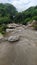 View of a brown wild dirty mountain river flowing through rocks