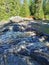 View of the bubbling waterfall with brown water on the Tokhmayoki River in Karelia from the ecological trail