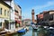 View of buildings and canal with tourists and boats in Murano, a nice little town on top of island