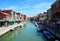 View of buildings and canal with tourists and boats in Murano, a nice little town on top of islands near Venice, Italy